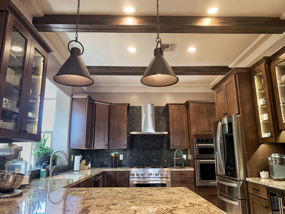 Mid-sized trendy u-shaped porcelain tile, beige floor and exposed beam open concept kitchen photo in Phoenix with an undermount sink, shaker cabinets, brown cabinets, granite countertops, black backsplash, mosaic tile backsplash, stainless steel appliances and beige countertops