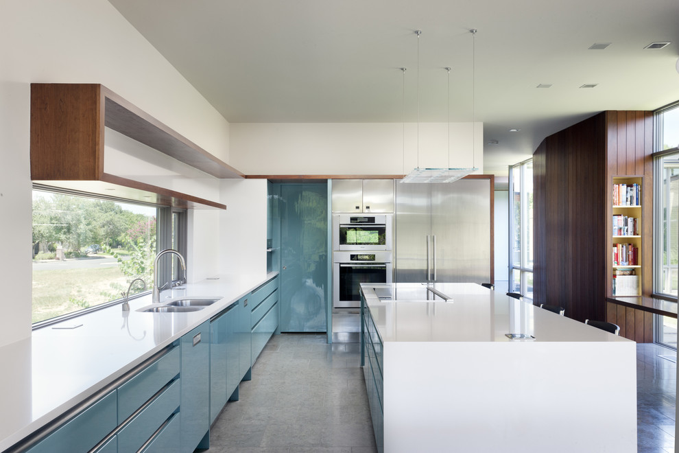 Example of a 1950s kitchen design in Austin with stainless steel appliances, quartz countertops, a double-bowl sink and flat-panel cabinets