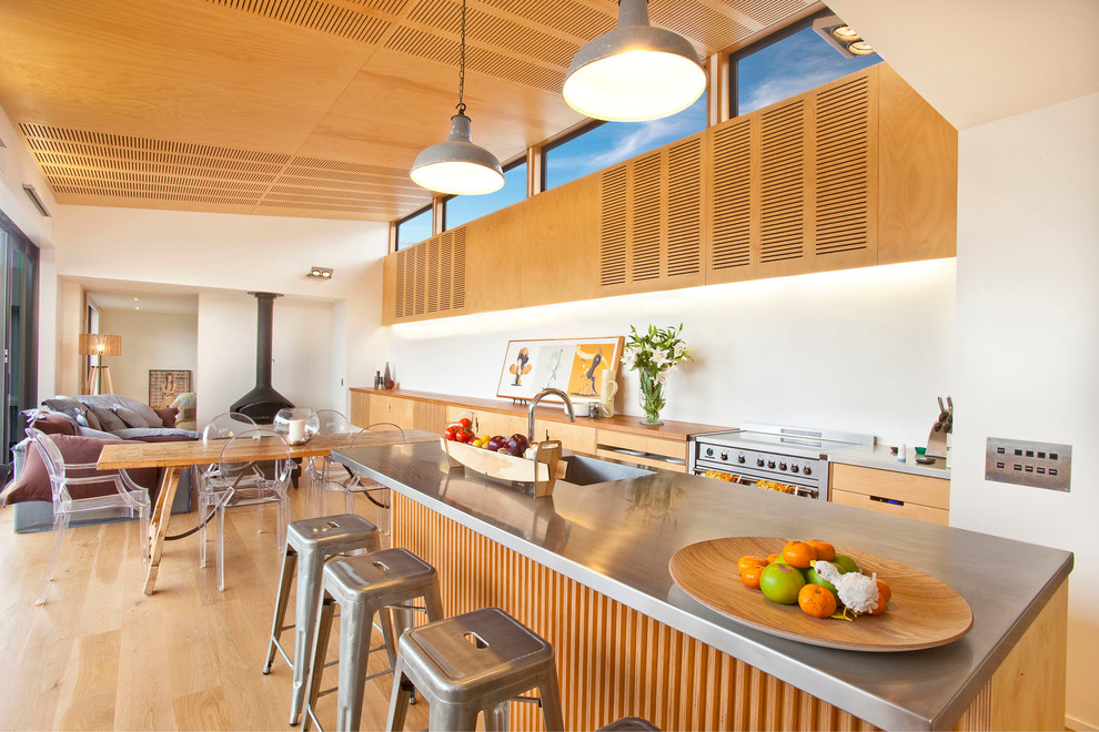 ハミルトンにあるコンテンポラリースタイルのおしゃれなキッチン (一体型シンク、フラットパネル扉のキャビネット、中間色木目調キャビネット、白いキッチンパネル、シルバーの調理設備) の写真