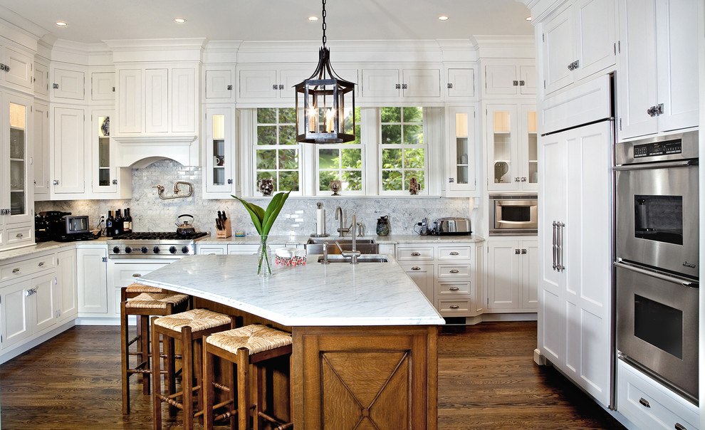 Inspiration for a timeless kitchen remodel in New York with a farmhouse sink, recessed-panel cabinets, white cabinets, white backsplash, stone tile backsplash and stainless steel appliances