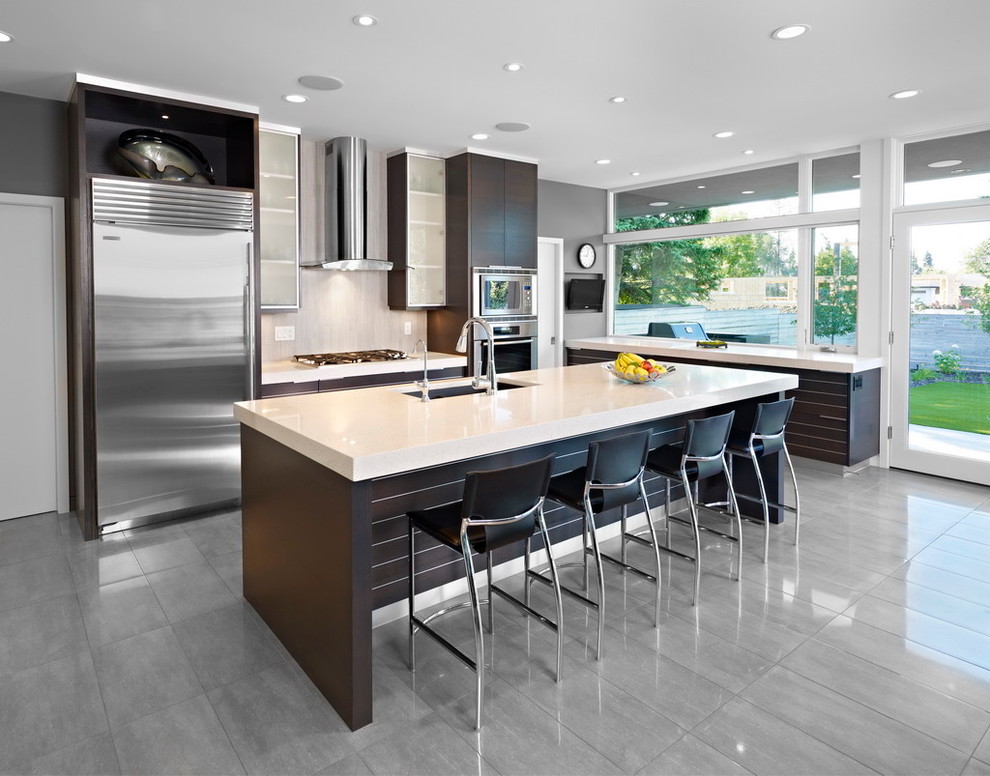 Modern kitchen in Edmonton with stainless steel appliances and grey floors.