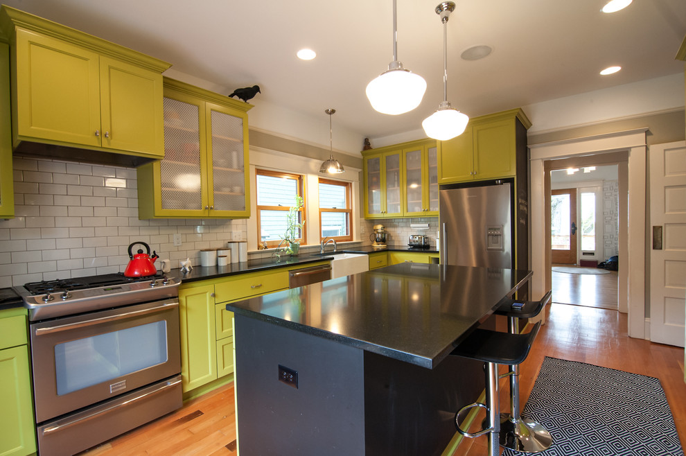 Photo of a bohemian kitchen in Portland with metro tiled splashback, a belfast sink and green cabinets.