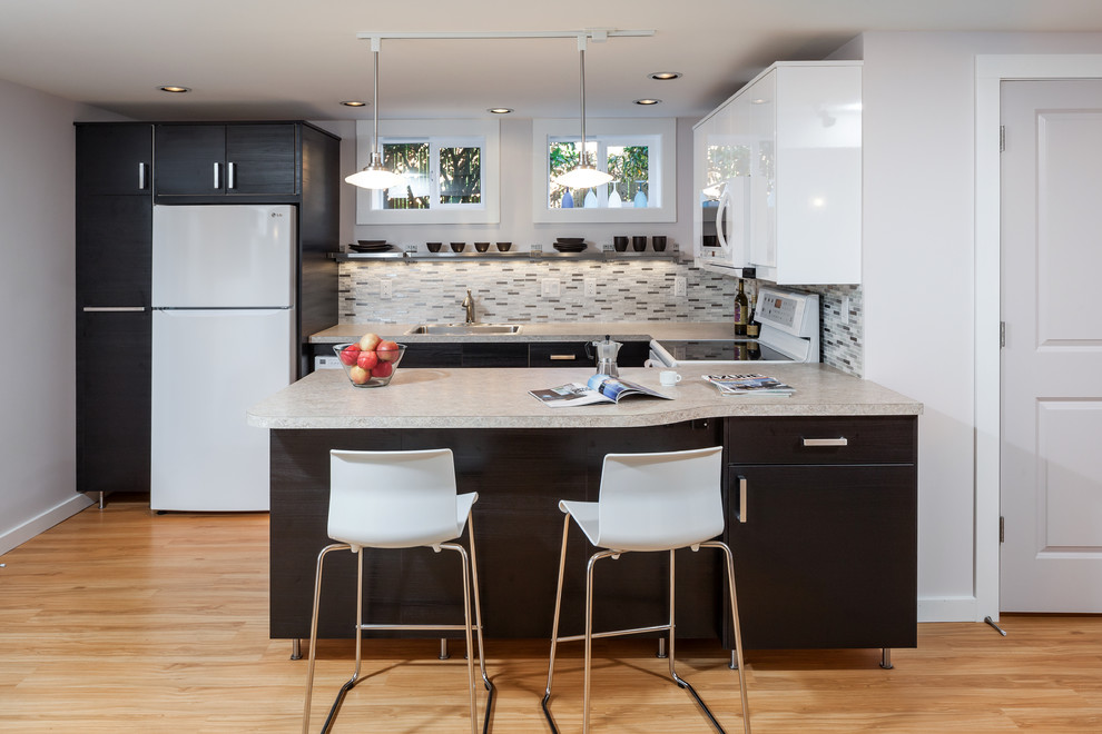 Inspiration for a mid-sized contemporary u-shaped light wood floor and beige floor eat-in kitchen remodel in Portland with a single-bowl sink, flat-panel cabinets, dark wood cabinets, solid surface countertops, multicolored backsplash, glass tile backsplash, white appliances and a peninsula
