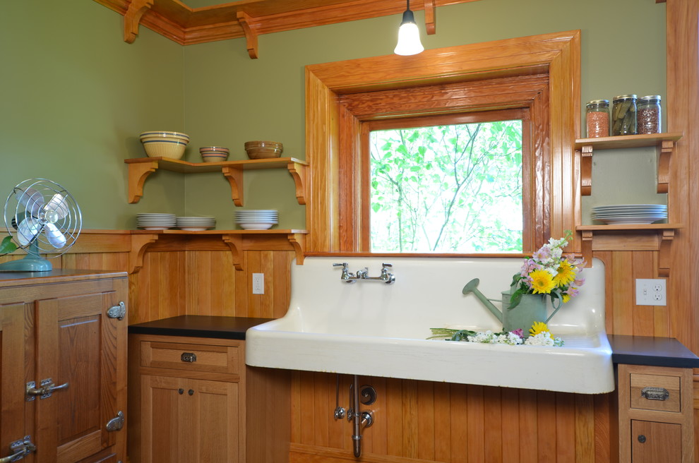 Idée de décoration pour une cuisine champêtre en bois clair fermée et de taille moyenne avec un évier de ferme, un placard à porte shaker, un plan de travail en granite et un sol en bois brun.