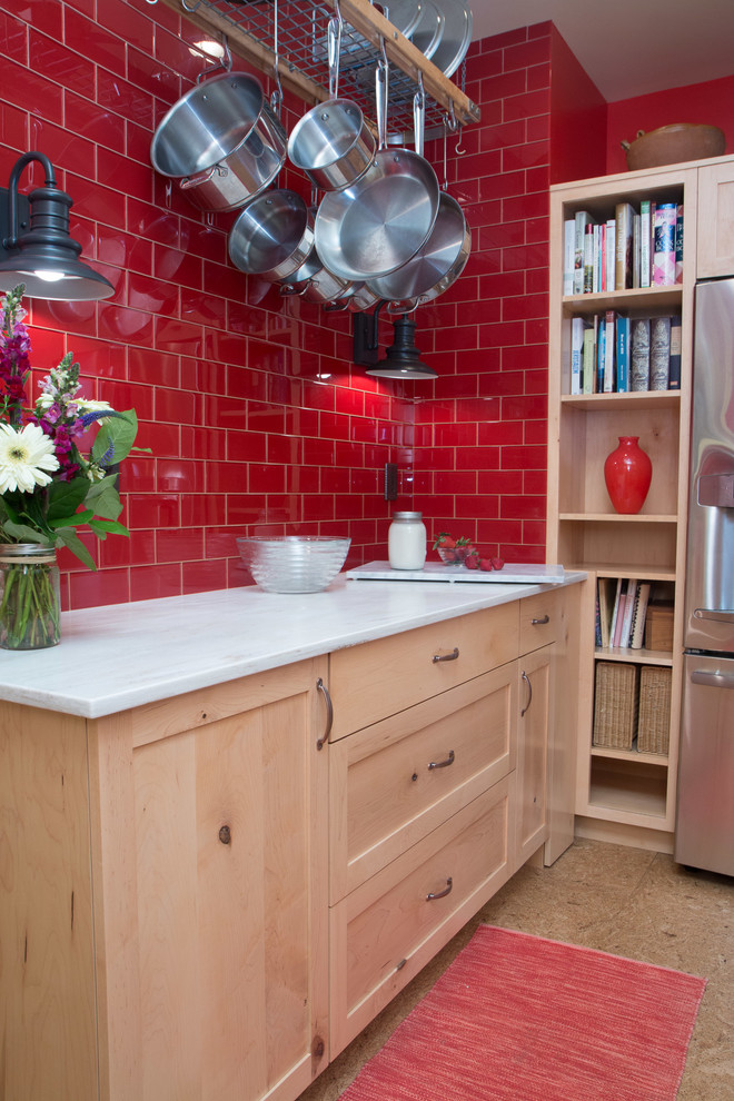 Foto på ett avskilt, mellanstort eklektiskt u-kök, med rött stänkskydd, rostfria vitvaror, korkgolv, en dubbel diskho, skåp i shakerstil, skåp i ljust trä, marmorbänkskiva, stänkskydd i porslinskakel, en halv köksö och beiget golv