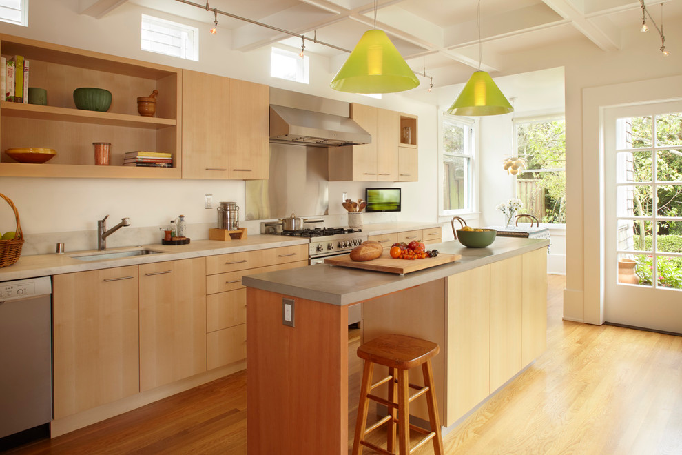 Пример оригинального дизайна: кухня в стиле модернизм с плоскими фасадами, светлыми деревянными фасадами и фартуком цвета металлик