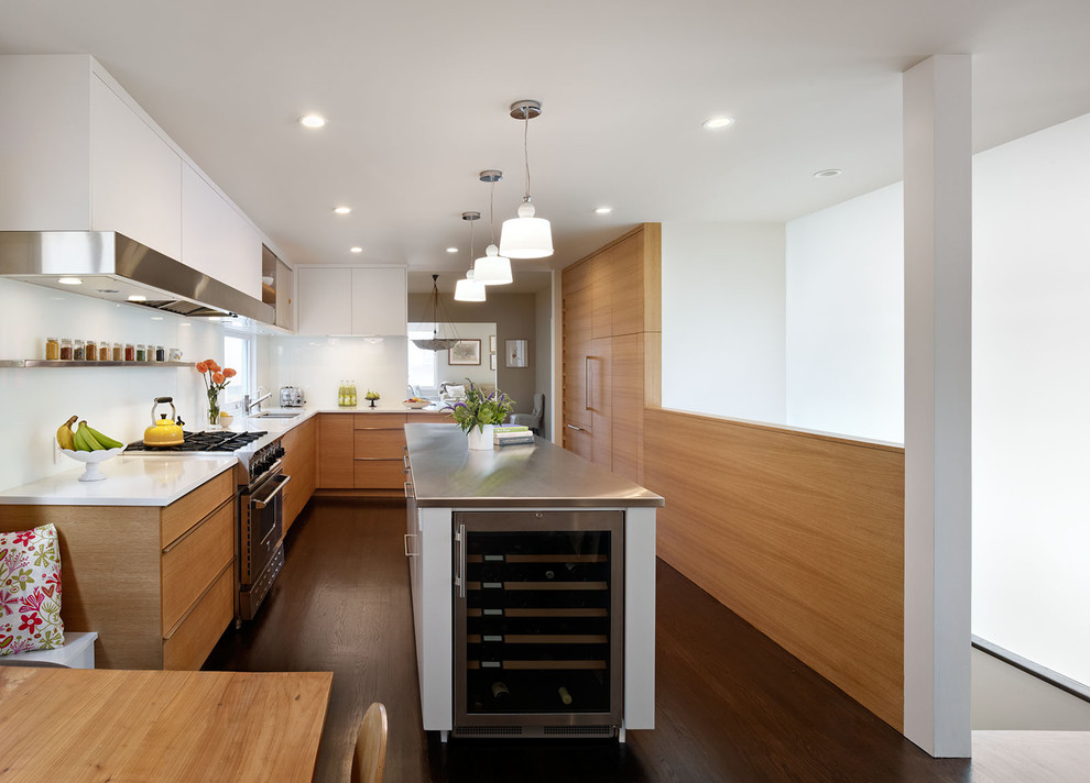 Inspiration for a modern kitchen in San Francisco with composite countertops, flat-panel cabinets, medium wood cabinets, white splashback, glass sheet splashback and stainless steel appliances.