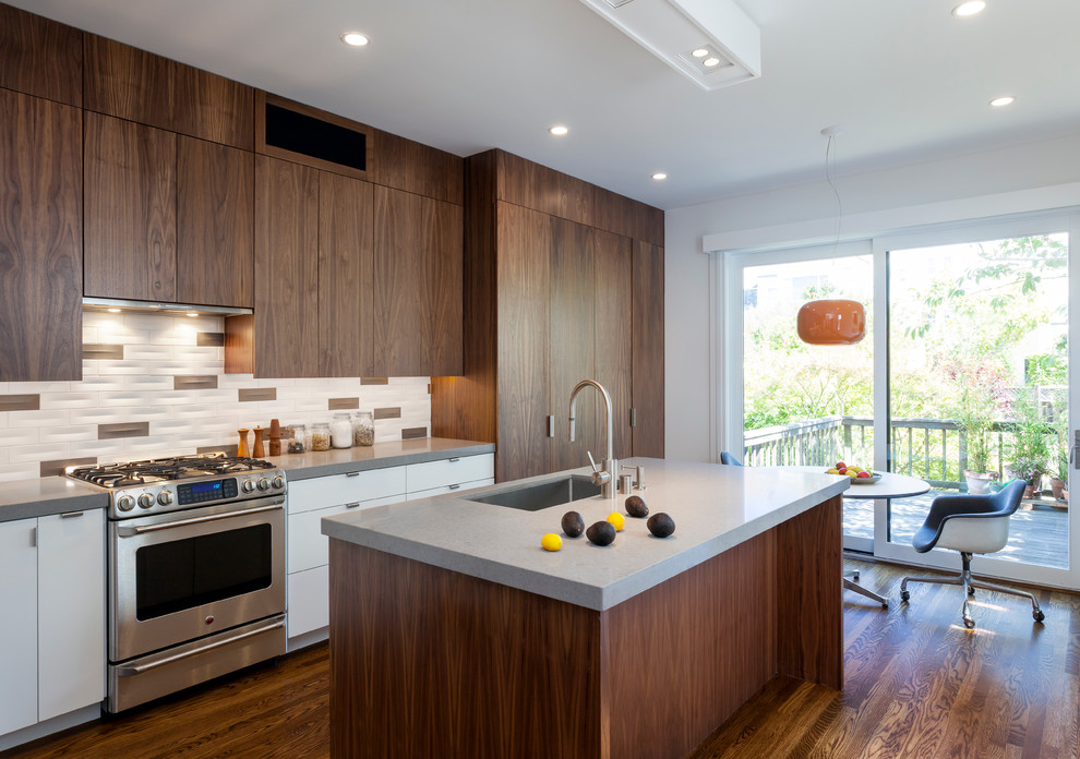 На фото: параллельная кухня в стиле модернизм с обеденным столом, плоскими фасадами, темными деревянными фасадами и разноцветным фартуком