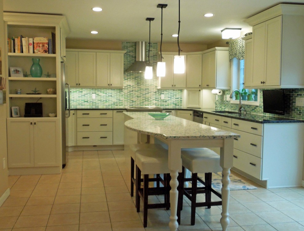 Inredning av ett klassiskt mellanstort kök, med en enkel diskho, luckor med infälld panel, vita skåp, granitbänkskiva, grönt stänkskydd, stänkskydd i glaskakel, rostfria vitvaror, klinkergolv i keramik och en köksö