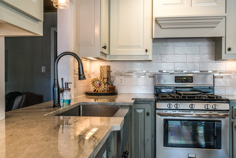 Mid-sized elegant l-shaped eat-in kitchen photo in Other with a farmhouse sink, quartzite countertops, white backsplash, porcelain backsplash, stainless steel appliances and an island