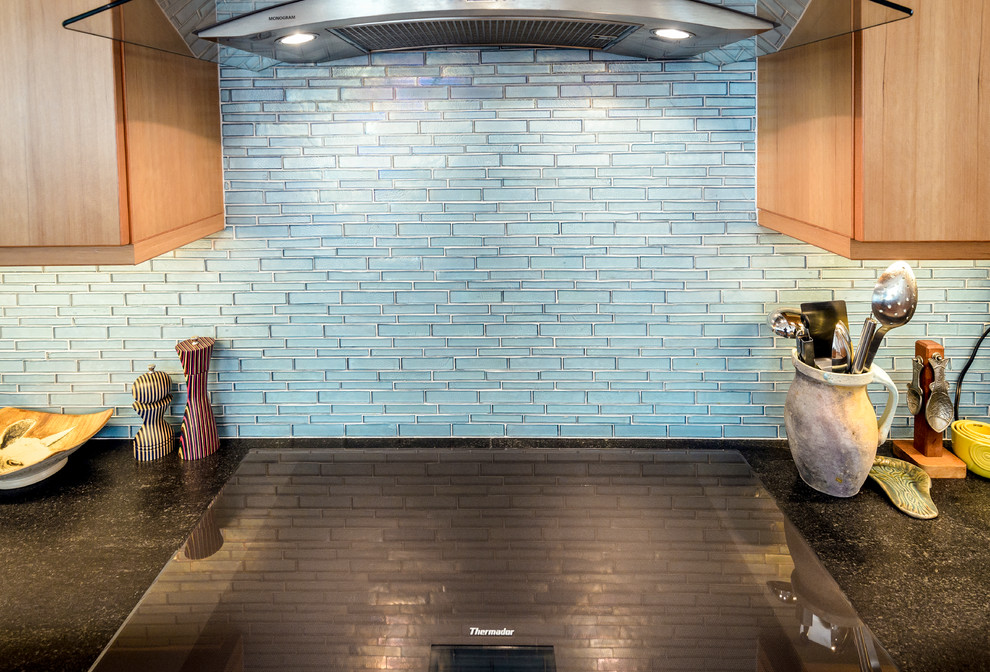Esempio di una cucina contemporanea di medie dimensioni con lavello sottopiano, ante in legno scuro, top in granito, paraspruzzi blu, paraspruzzi con piastrelle di vetro, elettrodomestici in acciaio inossidabile, pavimento in gres porcellanato, pavimento beige e ante lisce