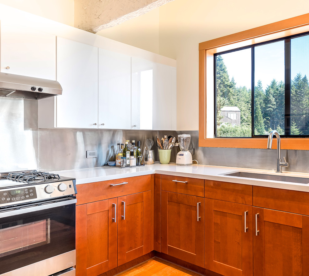 Inspiration for a mid-sized rustic u-shaped medium tone wood floor eat-in kitchen remodel in San Francisco with a single-bowl sink, shaker cabinets, medium tone wood cabinets, quartz countertops, metallic backsplash, metal backsplash, stainless steel appliances and a peninsula