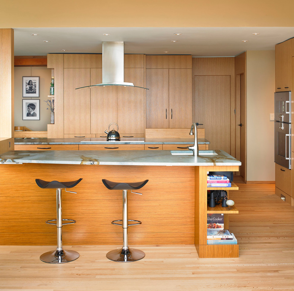 Moderne Küche mit flächenbündigen Schrankfronten, hellbraunen Holzschränken und Elektrogeräten mit Frontblende in Vancouver