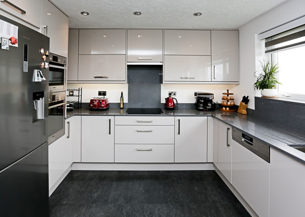 Moderne Küche ohne Insel in U-Form mit flächenbündigen Schrankfronten, weißen Schränken, Küchenrückwand in Grau und Küchengeräten aus Edelstahl in Sonstige