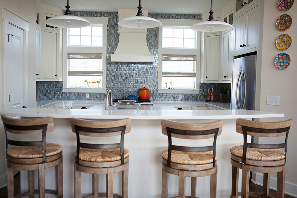 Immagine di una cucina costiera di medie dimensioni con lavello a doppia vasca, paraspruzzi con piastrelle in ceramica, elettrodomestici in acciaio inossidabile e pavimento in legno massello medio