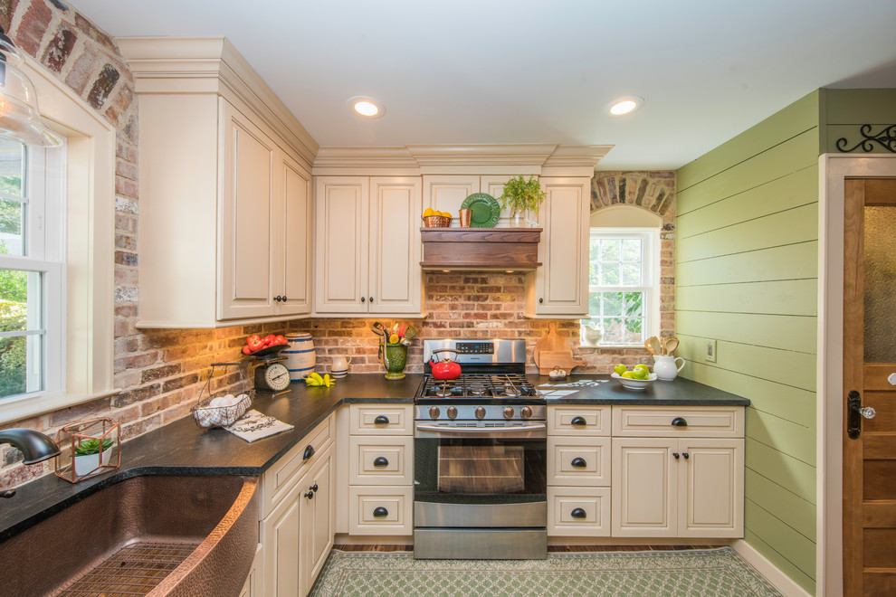 Foto på ett mellanstort, avskilt lantligt l-kök, med en rustik diskho, luckor med upphöjd panel, beige skåp, granitbänkskiva, stänkskydd i tegel och rostfria vitvaror