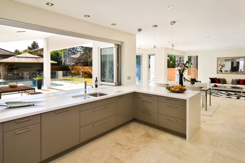 Photo of a large contemporary galley open plan kitchen in Sunshine Coast with an integrated sink, beaded cabinets, brown cabinets, marble worktops, window splashback, ceramic flooring, beige floors and white worktops.