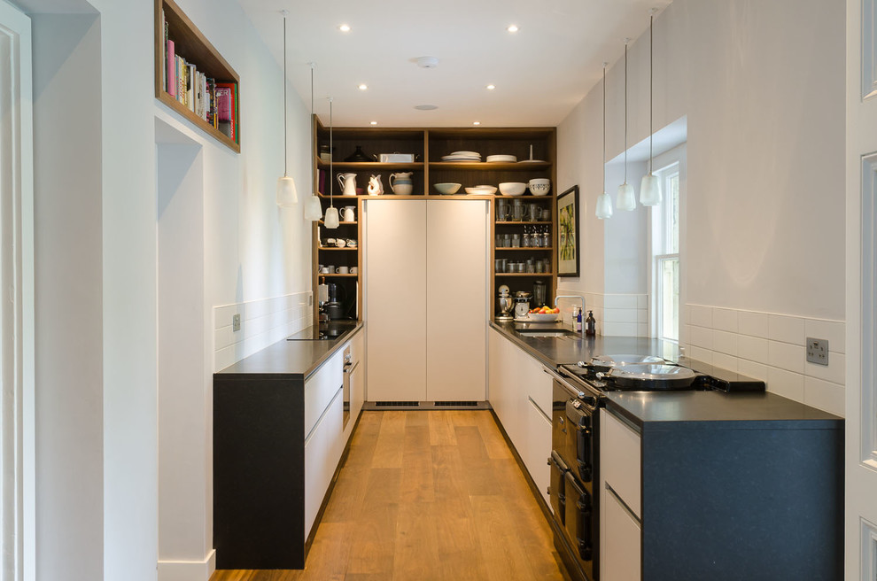 Enclosed kitchen - small contemporary u-shaped medium tone wood floor enclosed kitchen idea in Other with black appliances
