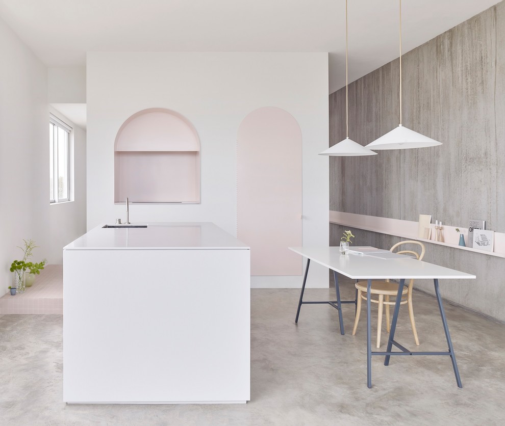 Inspiration for a scandi l-shaped kitchen/diner in Sydney with a submerged sink, flat-panel cabinets, cement flooring, an island and grey floors.