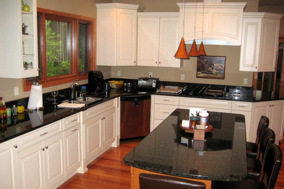 Foto på ett stort vintage kök, med en undermonterad diskho, luckor med upphöjd panel, vita skåp, granitbänkskiva, rostfria vitvaror, mörkt trägolv och en köksö