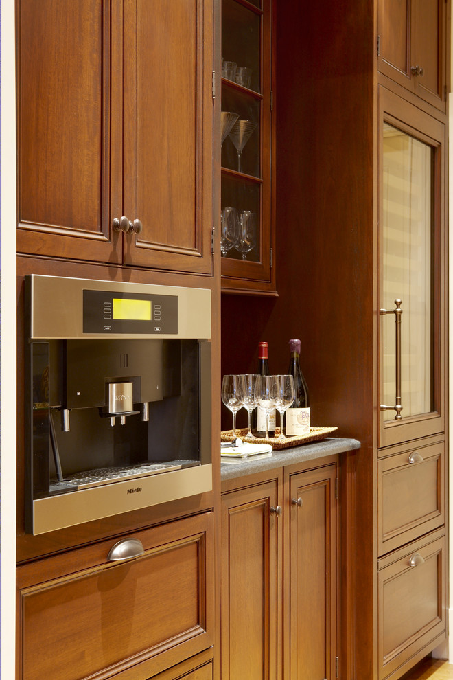 Example of a large classic single-wall medium tone wood floor and brown floor kitchen pantry design in Boston with recessed-panel cabinets, medium tone wood cabinets, marble countertops, paneled appliances and no island