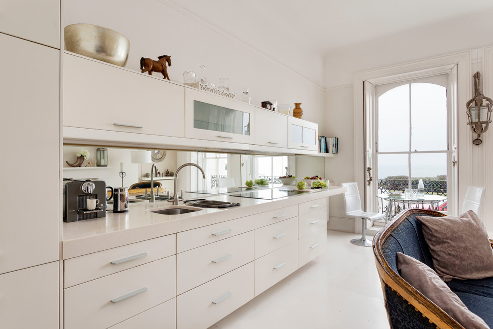 Immagine di una cucina lineare contemporanea chiusa e di medie dimensioni con lavello a doppia vasca, ante lisce, ante bianche, paraspruzzi a specchio e pavimento bianco