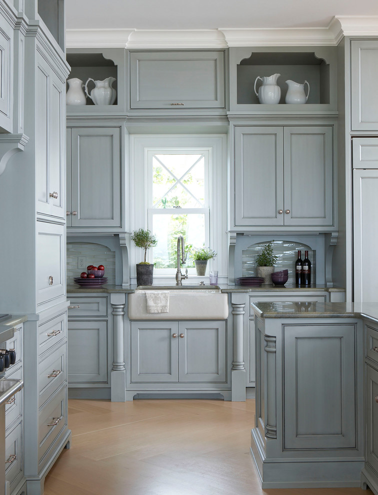 Inspiration for an expansive traditional l-shaped open plan kitchen in Boston with a belfast sink, beaded cabinets, blue cabinets, marble worktops, green splashback, glass tiled splashback, integrated appliances, light hardwood flooring, an island, beige floors and green worktops.