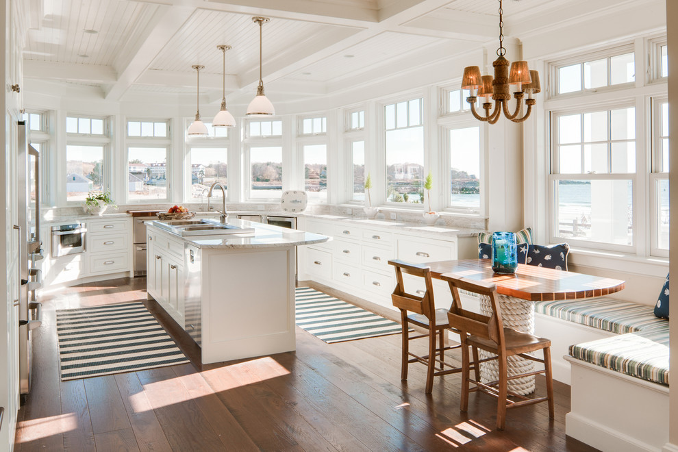 Maritime Küche in U-Form mit Schrankfronten im Shaker-Stil, weißen Schränken, dunklem Holzboden, Kücheninsel und braunem Boden in Portland Maine