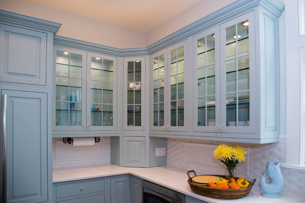 Immagine di una grande cucina costiera con paraspruzzi bianco, paraspruzzi con piastrelle a mosaico, lavello stile country, ante di vetro, ante blu, top in marmo, elettrodomestici da incasso e parquet scuro