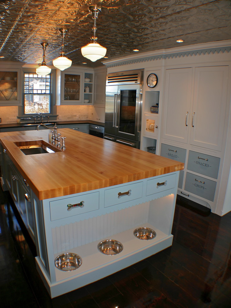 Elegant kitchen photo in Boston with an undermount sink, shaker cabinets, white cabinets, wood countertops, stainless steel appliances and brown countertops
