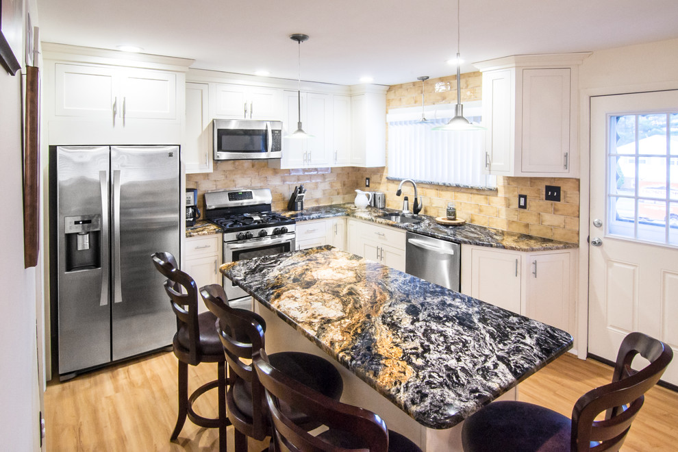 Eat-in kitchen - mid-sized mediterranean l-shaped eat-in kitchen idea in Philadelphia with an undermount sink, shaker cabinets, white cabinets, granite countertops, beige backsplash, ceramic backsplash, stainless steel appliances, an island and multicolored countertops