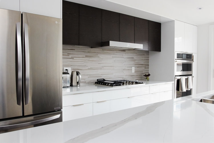 Inspiration for a mid-sized modern u-shaped porcelain tile and gray floor open concept kitchen remodel in Toronto with an undermount sink, flat-panel cabinets, white cabinets, quartz countertops, white backsplash, matchstick tile backsplash, stainless steel appliances, an island and white countertops