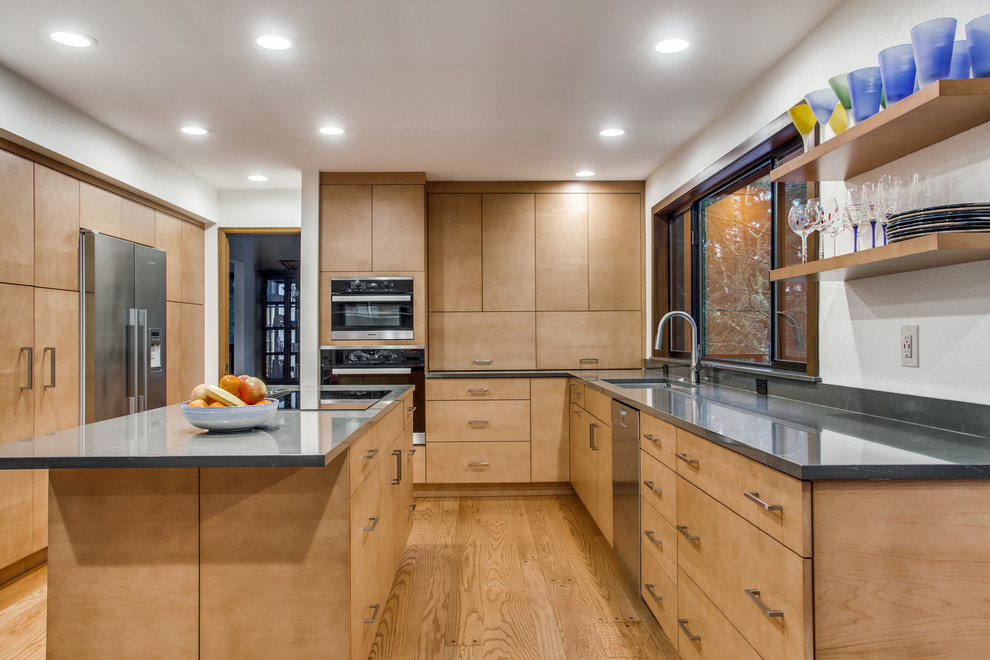 Mid-sized trendy galley medium tone wood floor and brown floor eat-in kitchen photo in Seattle with an undermount sink, flat-panel cabinets, light wood cabinets, quartz countertops, white backsplash, stainless steel appliances, an island and gray countertops