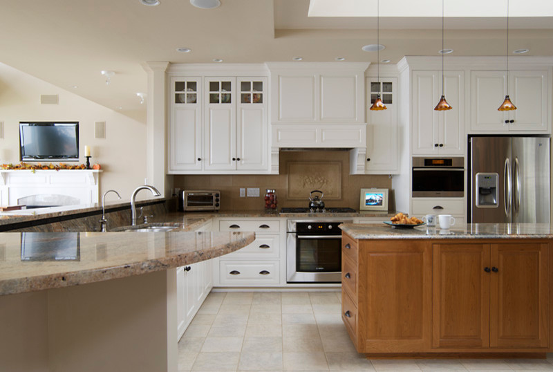 Example of a large classic u-shaped porcelain tile and beige floor enclosed kitchen design in Portland Maine with an undermount sink, white cabinets, granite countertops, stainless steel appliances, an island, raised-panel cabinets, beige backsplash and ceramic backsplash