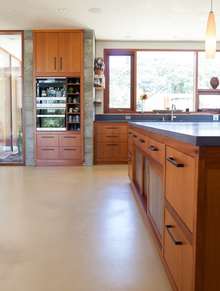 Large zen concrete floor kitchen photo in San Francisco with concrete countertops, stainless steel appliances and an island