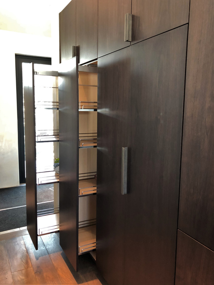 Large trendy galley medium tone wood floor, brown floor and vaulted ceiling open concept kitchen photo in Other with an undermount sink, flat-panel cabinets, dark wood cabinets, colored appliances, an island and multicolored countertops