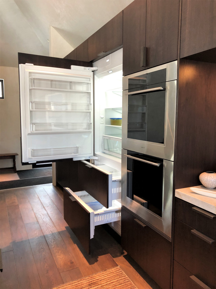 Inspiration for a large contemporary galley medium tone wood floor, brown floor and vaulted ceiling open concept kitchen remodel in Other with an undermount sink, flat-panel cabinets, dark wood cabinets, colored appliances, an island and multicolored countertops