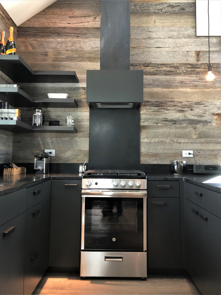 Open concept kitchen - mid-sized contemporary u-shaped light wood floor, orange floor and vaulted ceiling open concept kitchen idea in Other with an undermount sink, flat-panel cabinets, black cabinets, brown backsplash, stainless steel appliances, a peninsula and brown countertops