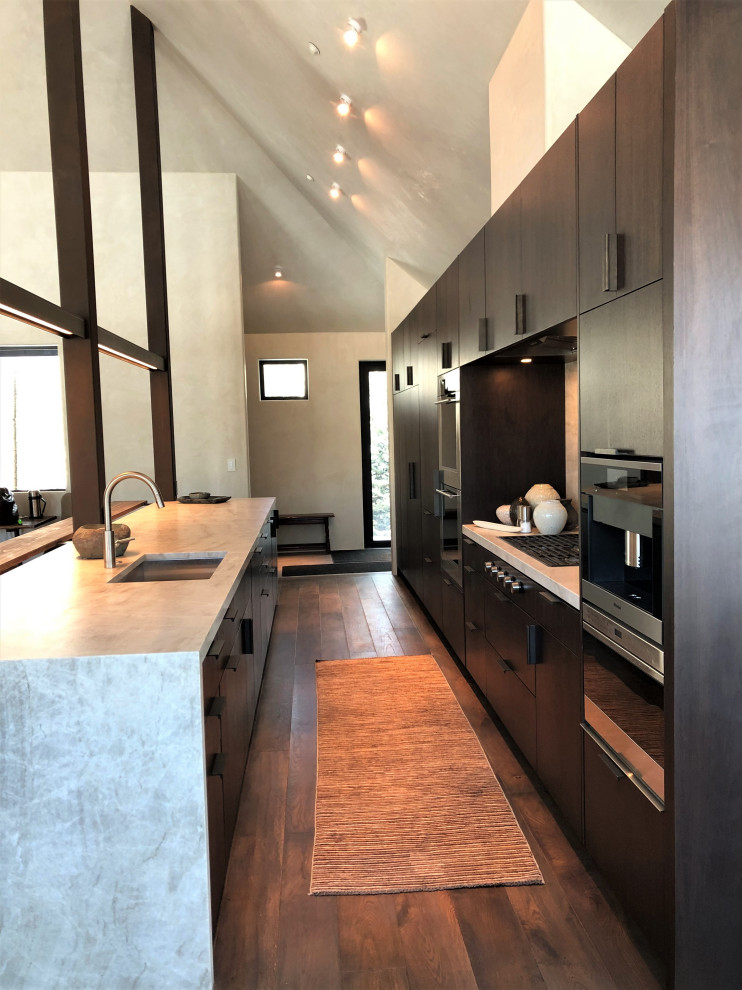 Open concept kitchen - large contemporary galley medium tone wood floor, brown floor and vaulted ceiling open concept kitchen idea in Other with an undermount sink, flat-panel cabinets, dark wood cabinets, colored appliances, an island and multicolored countertops