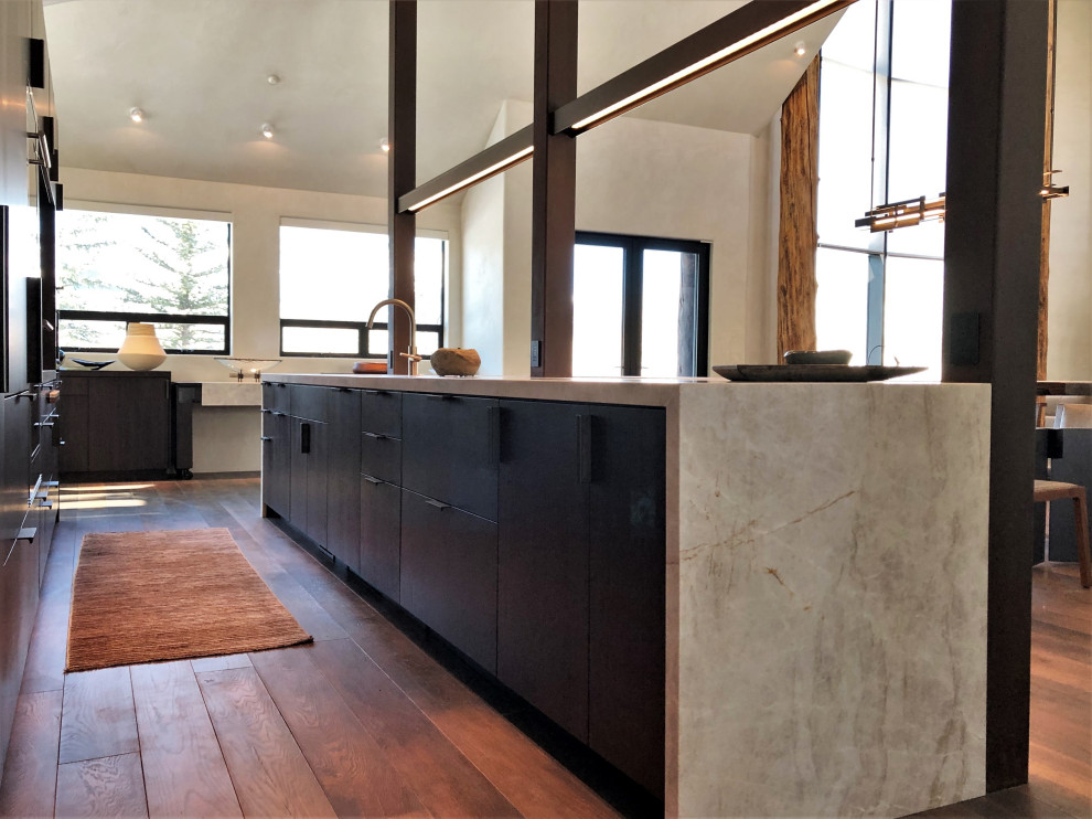 Large trendy galley medium tone wood floor, brown floor and vaulted ceiling open concept kitchen photo in Other with an undermount sink, flat-panel cabinets, dark wood cabinets, colored appliances, an island and multicolored countertops