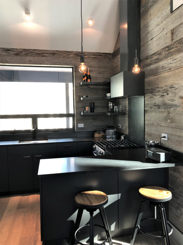 Inspiration for a mid-sized contemporary u-shaped light wood floor, orange floor and vaulted ceiling open concept kitchen remodel in Other with an undermount sink, flat-panel cabinets, black cabinets, brown backsplash, stainless steel appliances, a peninsula and brown countertops