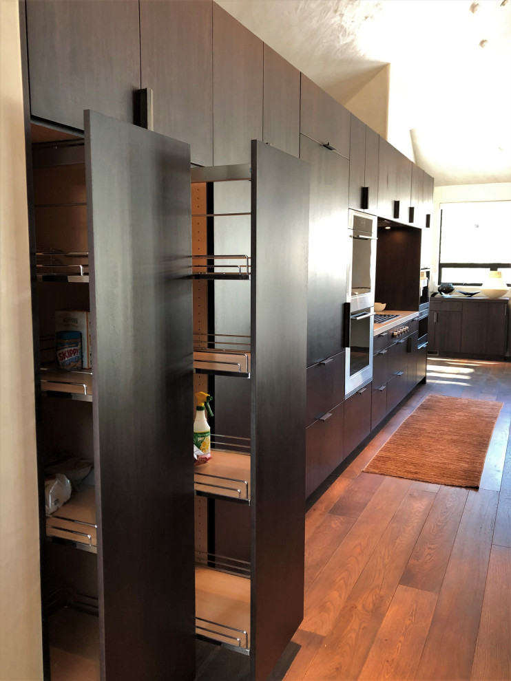 Open concept kitchen - large contemporary galley medium tone wood floor, brown floor and vaulted ceiling open concept kitchen idea in Other with an undermount sink, flat-panel cabinets, dark wood cabinets, colored appliances, an island and multicolored countertops