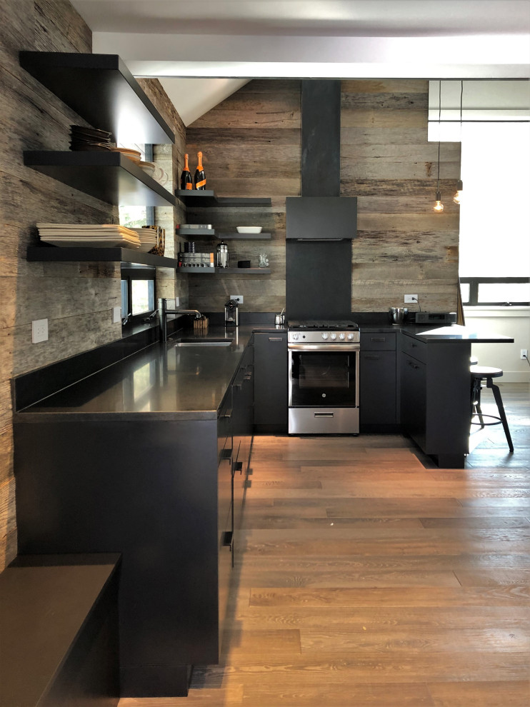 Open concept kitchen - mid-sized contemporary u-shaped light wood floor, orange floor and vaulted ceiling open concept kitchen idea in Other with an undermount sink, flat-panel cabinets, black cabinets, brown backsplash, stainless steel appliances, a peninsula and brown countertops