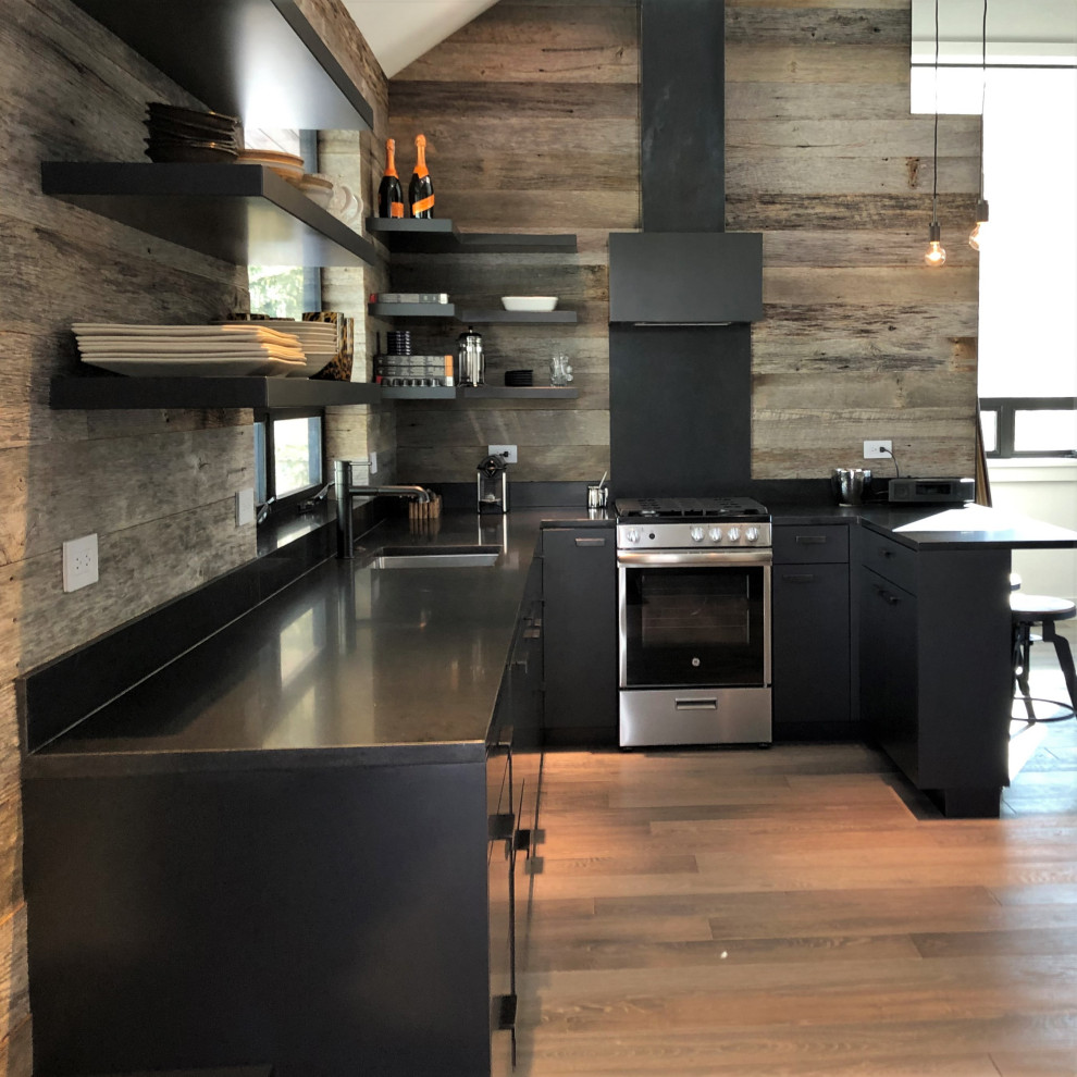 Inspiration for a mid-sized contemporary u-shaped light wood floor, orange floor and vaulted ceiling open concept kitchen remodel in Other with an undermount sink, flat-panel cabinets, black cabinets, brown backsplash, stainless steel appliances, a peninsula and brown countertops