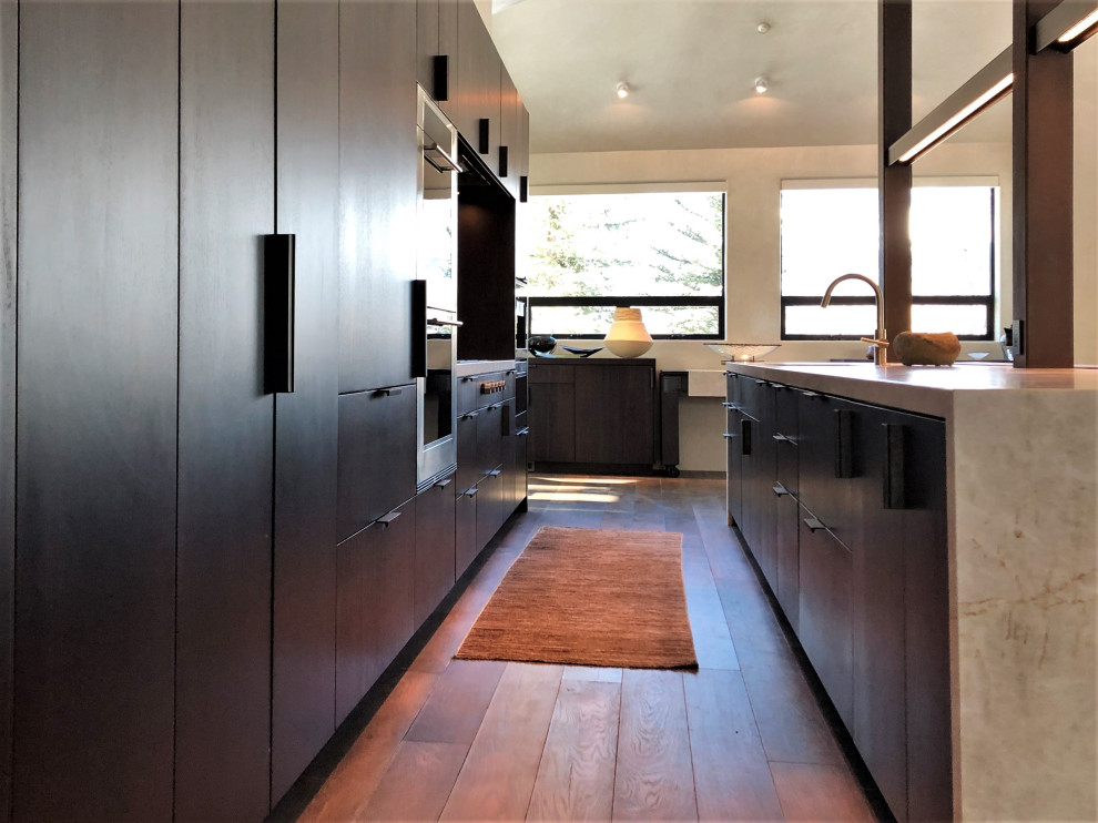 Open concept kitchen - large contemporary galley medium tone wood floor, brown floor and vaulted ceiling open concept kitchen idea in Other with an undermount sink, flat-panel cabinets, dark wood cabinets, colored appliances, an island and multicolored countertops