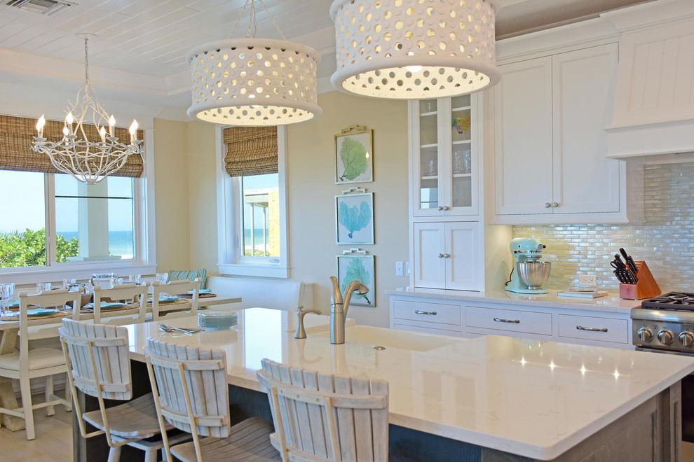 Foto på ett mellanstort maritimt linjärt kök och matrum, med en rustik diskho, luckor med infälld panel, vita skåp, beige stänkskydd, stänkskydd i glaskakel, rostfria vitvaror, ljust trägolv och en köksö