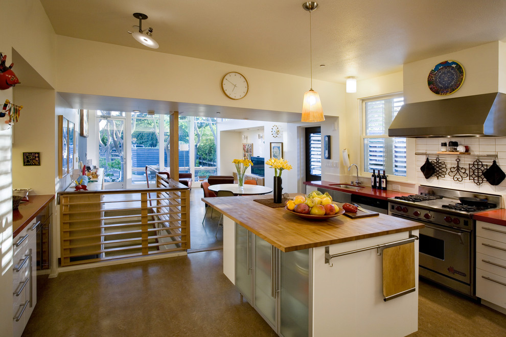 Moderne Wohnküche mit Küchengeräten aus Edelstahl, Arbeitsplatte aus Holz, flächenbündigen Schrankfronten, weißen Schränken und Küchenrückwand in Weiß in San Francisco