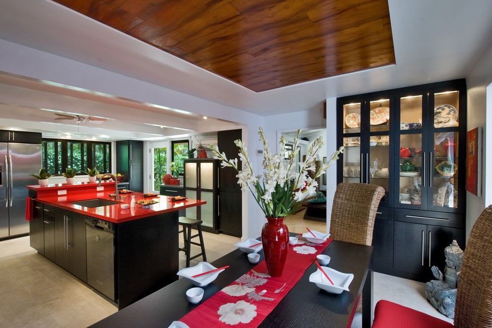This is an example of a contemporary kitchen/diner in Hawaii with a submerged sink, flat-panel cabinets, dark wood cabinets, composite countertops, grey splashback and stainless steel appliances.