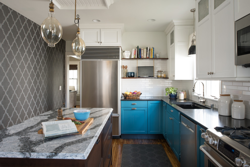 Geschlossene Klassische Küche in L-Form mit Waschbecken, Schrankfronten im Shaker-Stil, blauen Schränken, Küchenrückwand in Weiß, Küchengeräten aus Edelstahl, braunem Holzboden und Kücheninsel in Minneapolis