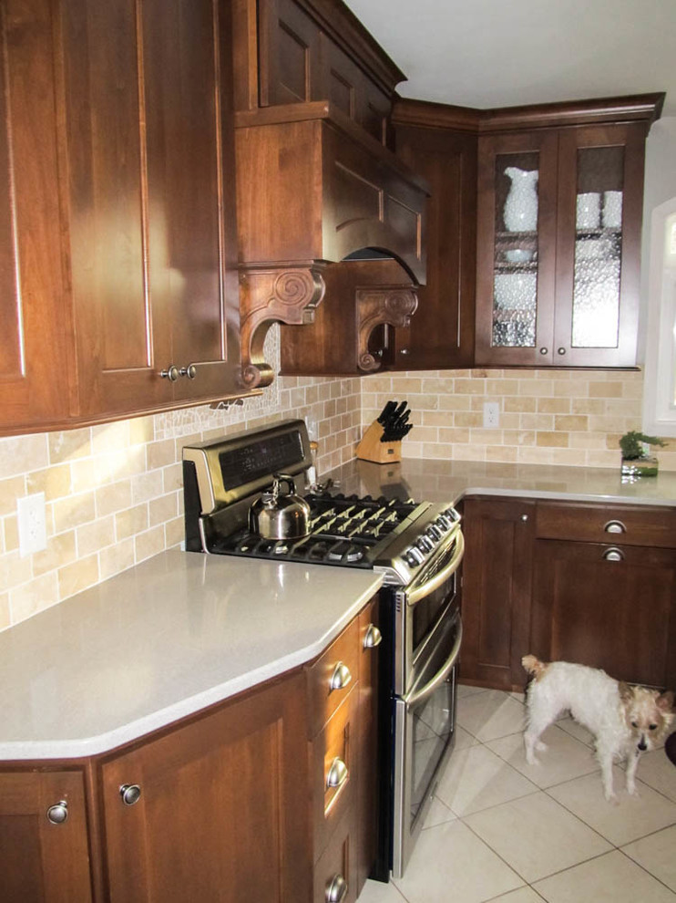 Klassisk inredning av ett mellanstort kök, med en undermonterad diskho, skåp i shakerstil, skåp i mörkt trä, bänkskiva i kvarts, rostfria vitvaror, en halv köksö, beige stänkskydd, stänkskydd i stenkakel och klinkergolv i keramik